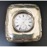 CONTINENTAL SILVER CASED POCKET WATCH IN SILVER MOUNTED STAND the white enamel dial marked 'Kendal &