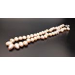 FRESHWATER BAROQUE PEARL NECKLACE the individually knotted pearls with a pink hue, approximately