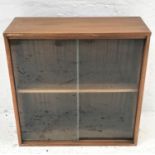 TEAK BOOKCASE with a pair of glass sliding door and an adjustable shelf, standing on a plinth