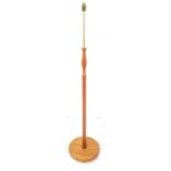 TEAK STANDARD LAMP raised on a circular base with a turned and shaped column with a brass column