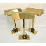 THREE BRASS TABLE LIGHTS with oblong shaped hoods raised on a square column and oblong base, 50cm