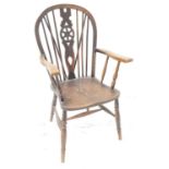 20th CENTURY OAK WHEELBACK ARM CHAIR with an arched stick back and shaped arms above a shaped