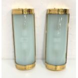TWO DOMED WALL LIGHTS with brass frames and opaque glass shades, 50cm long