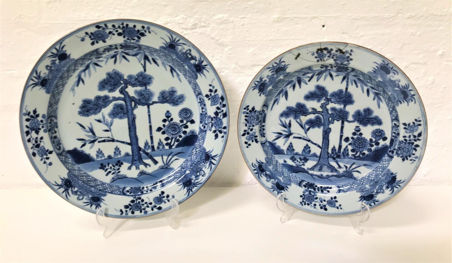TWO CHINESE CHARGERS both decorated in blue and white with a floral border around a central tree,