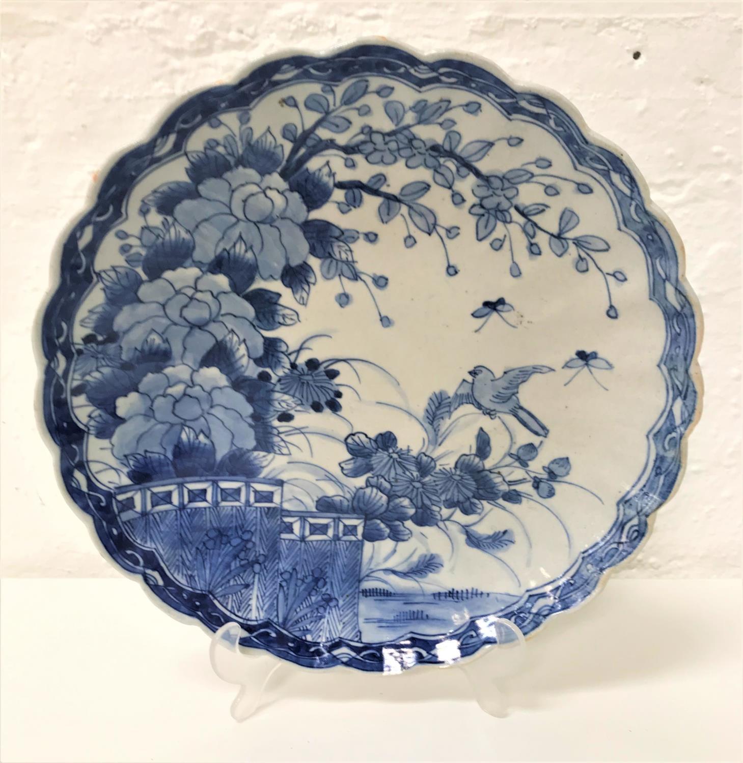 CHINESE CHARGER with a wavy rim decorated in blue and white with flowers and a bird, the underside