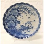 CHINESE CHARGER with a wavy rim decorated in blue and white with flowers and a bird, the underside
