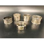 FIVE VARIOUS SILVER NAPKIN RINGS comprising a pair of plain design with monograms JW and NW, by