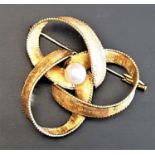 UNMARKED HIGH CARAT GOLD BROOCH the brooch of entwined form with central peal and textured finish to