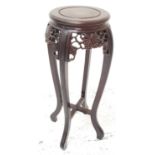 CHINESE HARDWOOD JARDINERE STAND with a circular top above a carved and pierced frieze decorated