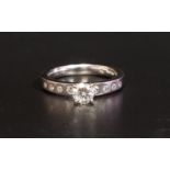 DIAMOND SOLITAIRE RING the round brilliant cut diamond approximately 0.4cts, flanked by four small