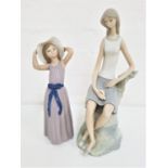 TWO LLADRO FIGURINES one depicting a young girl holding onto her hat, 25.5cm high, the other of a