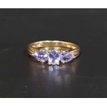 TANZANITE THREE STONE RING the central oval cut stone flanked by pear cut stones to each side, on