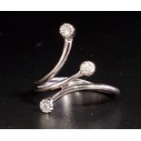 ATTRACTIVE DIAMOND RING formed with three outswept arms, each terminating with a small diamond, in