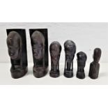 PAIR OF EBONY AFRICAN CARVED BOOKENDS depicting tribes men, 25.5cm high, together with four other