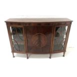 MAHOGANY BOW FRONT SIDE CABINET with a decorative frieze above a central paneled door, flanked by