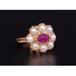 RUBY AND PEARL CLUSTER RING the central oval cabochon ruby in eight pearl surround, on nine carat