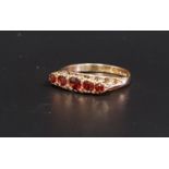 GRADUATED GARNET FIVE STONE RING on nine carat gold shank with decorative pierced and scroll