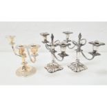 PAIR OF SILVER PLATED THREE BRANCH CANDELABRA with scroll arms, raised on square shaped bases, 22.