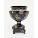 CARLTON WARE URN SHAPED PEDESTAL VASE with a navy blue ground decorated with gilt pagodas, 15cm high