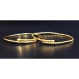TWO HIGH CARAT GOLD CHRISTENING BANGLES one marked 916, the other unmarked but testing as 22 carat