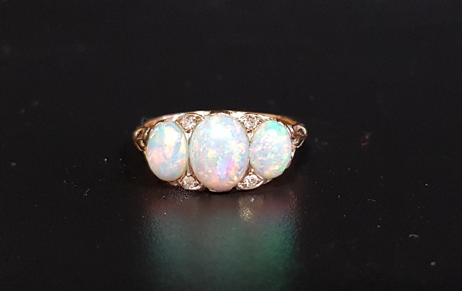 PRETTY OPAL AND DIAMOND RING the three graduated oval cabochon opals with small diamonds between, on