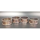 SET OF FOUR SILVER NAPKIN RINGS with decorative rims, Birmingham 1964 and 1965, total weight