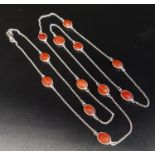CARNELIAN SET SILVER NECKLACE the twelve faceted carnelians separated by silver chain sections, 94cm