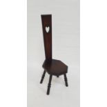 MAHOGANY SPINNING CHAIR with a tapering back and heart shaped cut out handle above a shaped seat,