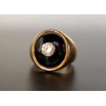 DIAMOND AND ONYX SIGNET RING the central bezel set round brilliant cut diamond approximately 0.