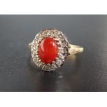 CORAL AND DIAMOND CLUSTER RING the central oval cabochon coral stone in diamond surround, on nine