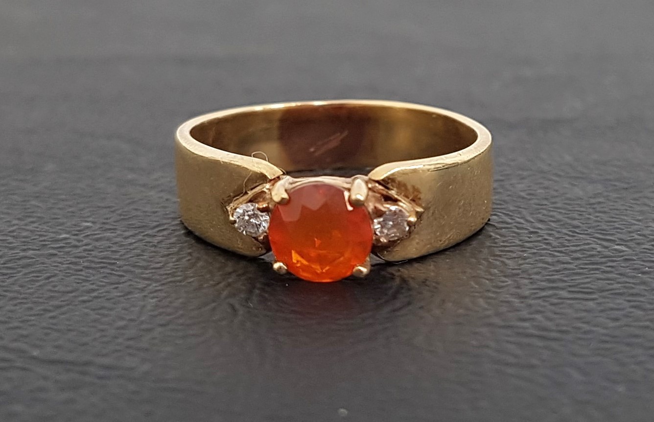 FIRE OPAL AND DIAMOND THREE STONE RING the central round cut fire opal flanked by small diamonds, on