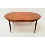 G PLAN TEAK EXTENDING DINING TABLE with an oval pull apart and fold out leaf, standing on four