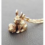 NINE CARAT GOLD RABBIT PENDANT formed as adult and kitten, on nine carat gold chain of approximately