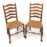 PAIR OF ELM LANCASHIRE LADDER BACK CHAIRS with woven rush seats, standing on tapering front supports