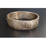 SILVER BANGLE the hinged bangle with engraved scroll decoration, the bangle width approximately 1.
