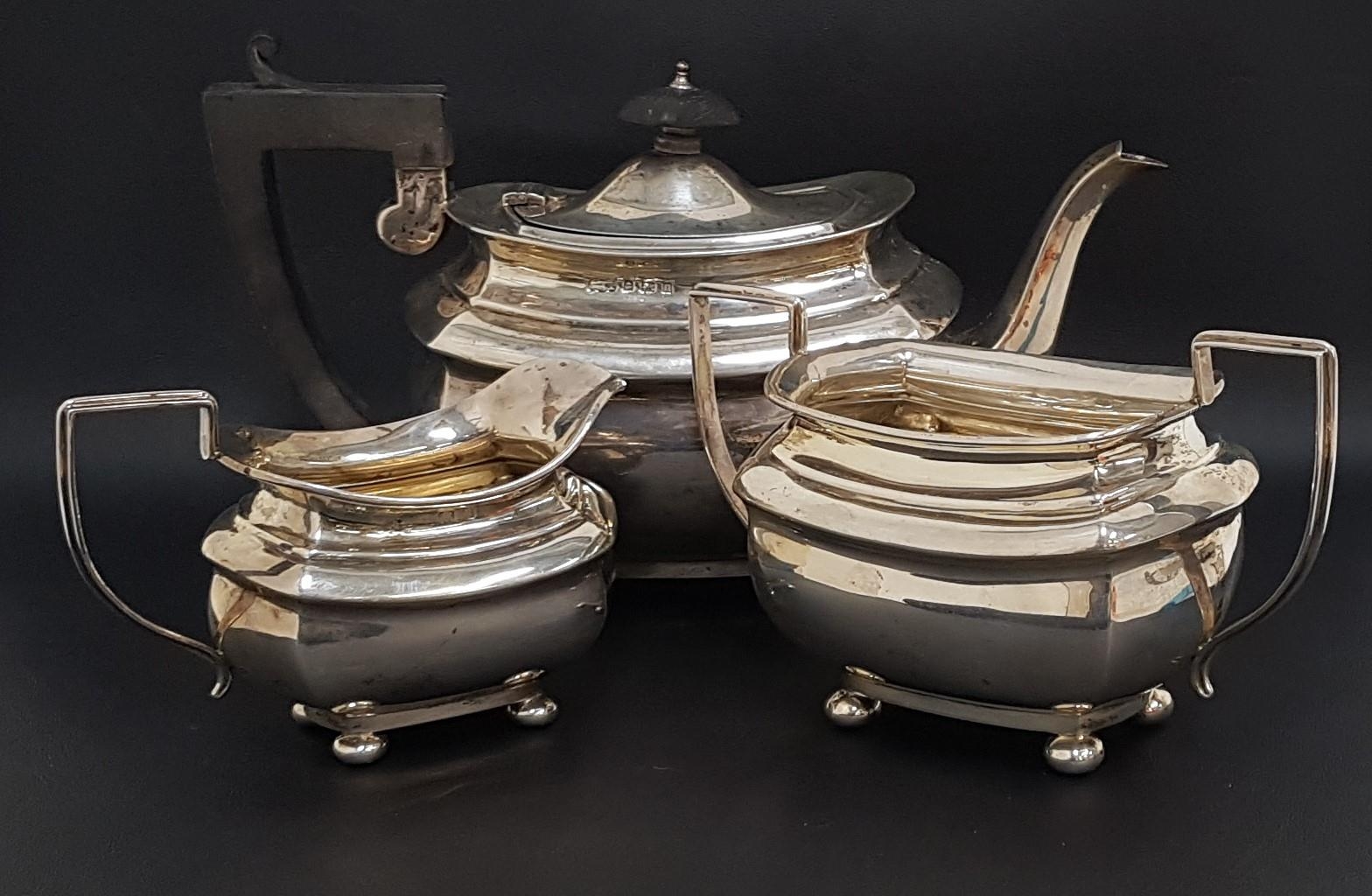 GEORGE V SILVER TEA SET comprising a tea pot, milk jug and twin handled sugar bowl raised on