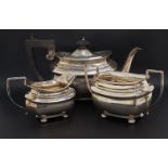 GEORGE V SILVER TEA SET comprising a tea pot, milk jug and twin handled sugar bowl raised on