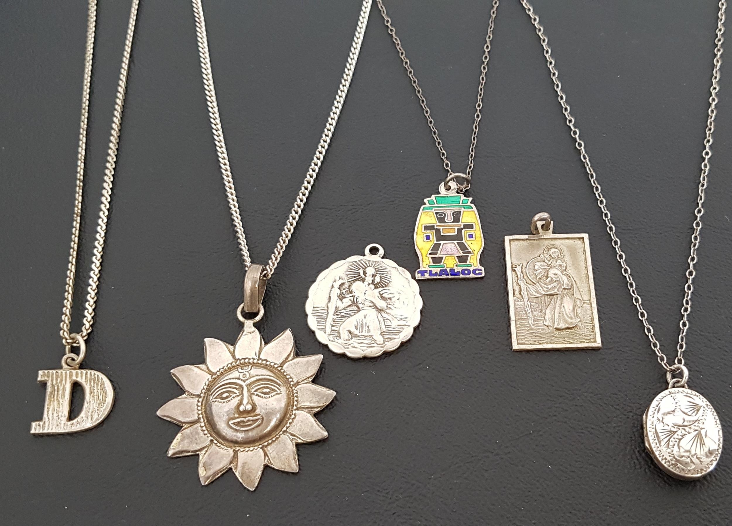 SIX SILVER PENDANTS including two Saint Christopher pendants, one with car and plane to reverse; a