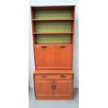G PLAN TEAK WALL UNIT with adjustable shelves above a fall flap opening to reveal a fitted interior,