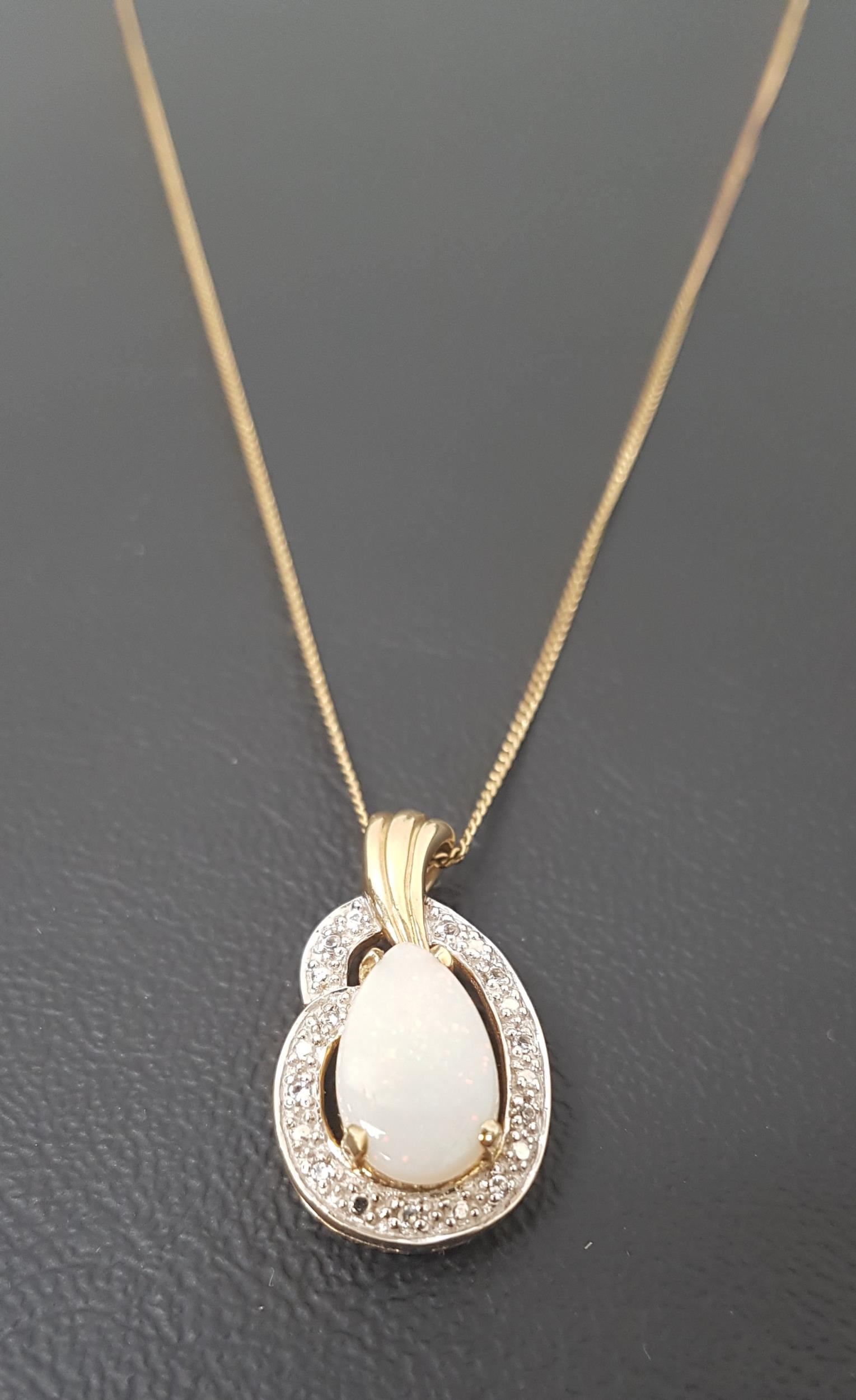 OPAL AND DIAMOND PENDANT the pear shaped opal in illusion set diamond surround, in nine carat gold
