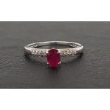 RUBY AND DIAMOND RING the central oval cut ruby approximately 0.4cts flanked by pave set diamonds