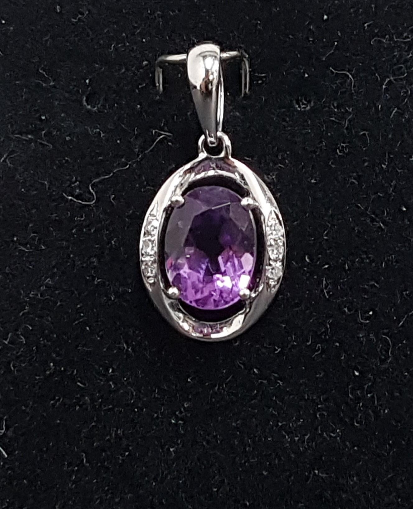 AMETHYST AND DIAMOND PENDANT the central oval cut amethyst flanked by three diamonds to each side of