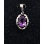 AMETHYST AND DIAMOND PENDANT the central oval cut amethyst flanked by three diamonds to each side of