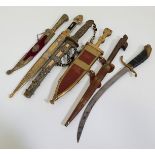 SELECTION OF SIX DECORATIVE DAGGERS including an Indian example with a 23cm long blade with a carved