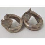 PAIR OF AFRICAN WHITE METAL HINGED BANGLES with chased decoration and pin closure (2)