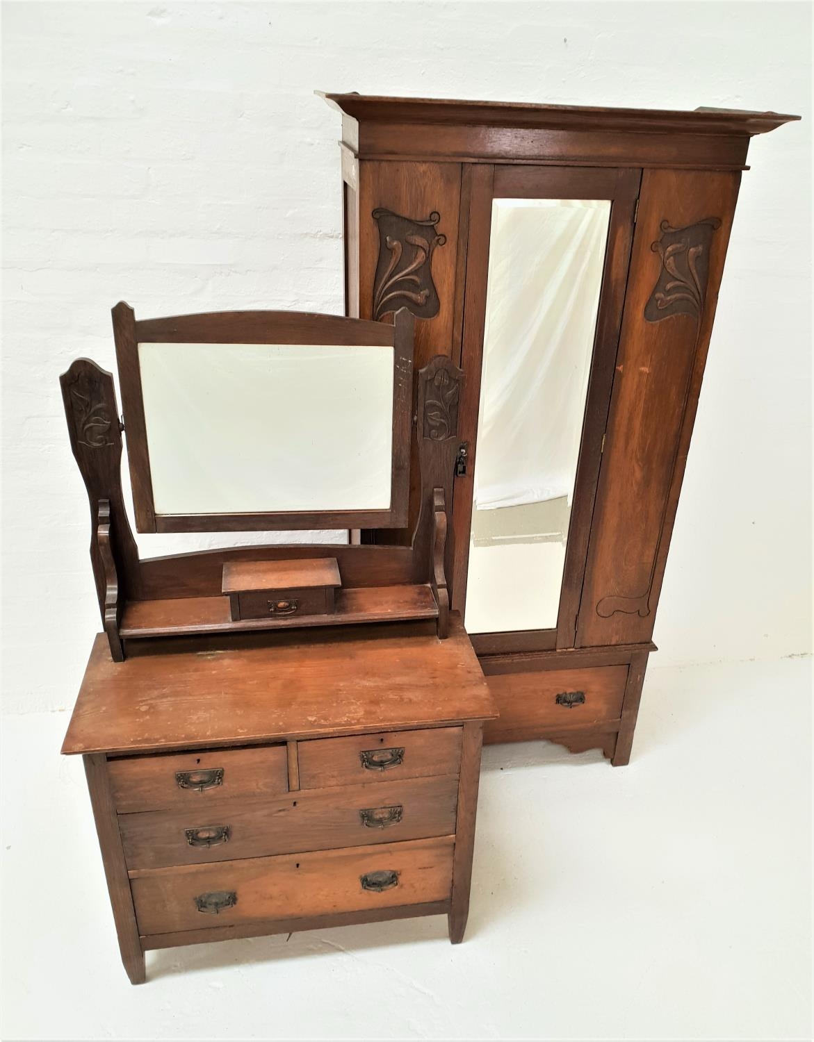 ARTS AND CRAFTS OAK WARDROBE with a moulded cornice above a central mirrored door flanked by