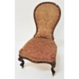 VICTORIAN NURSING CHAIR with a shaped spoon back above a shaped stuffover seat, standing on cabriole