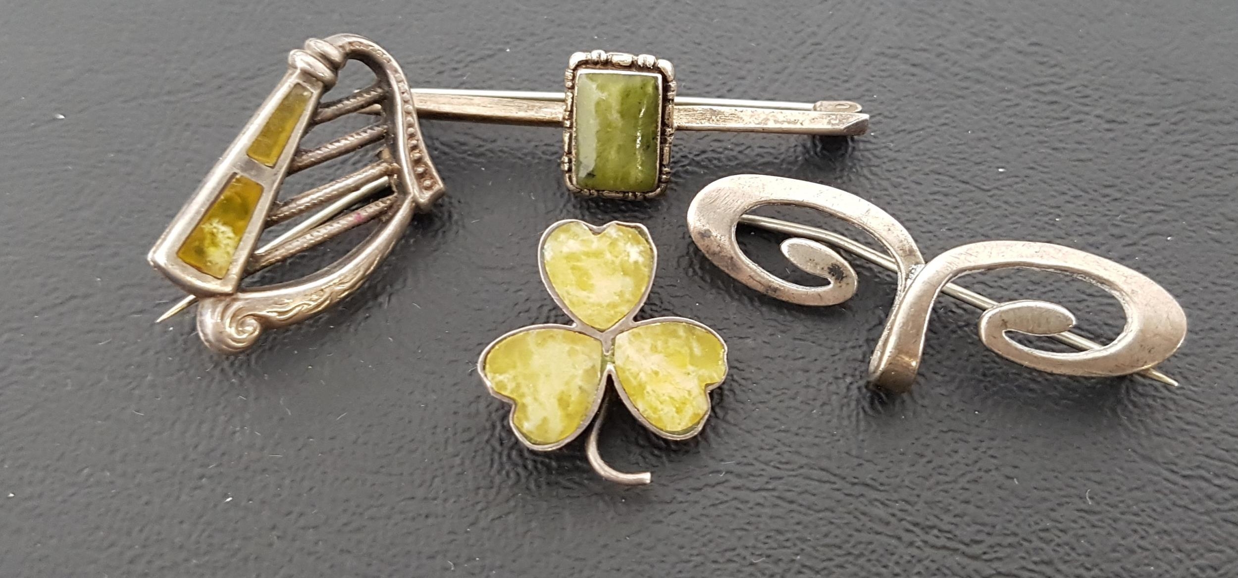 FOUR SILVER BROOCHES comprising a green agate set harp brooch; another green agate set three leaf