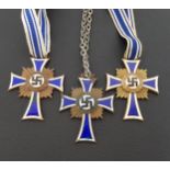 THREE WWII NAZI GERMAN CROSS OF HONOUR OF THE GERMAN MOTHER DECORATION in brass with blue and