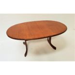 G PLAN TEAK EXTENDING DINNING TABLE with an oval pull apart top and fold out leaf, standing on